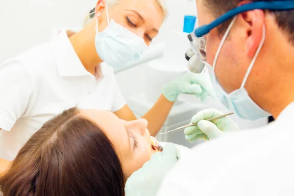 Mujer joven recibiendo un tratamiento en el dentista — Foto de Stock