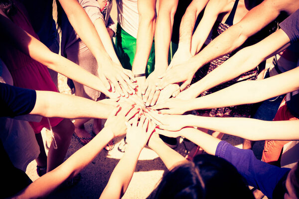 большая группа молодых людей, поднимающих руки вместе
