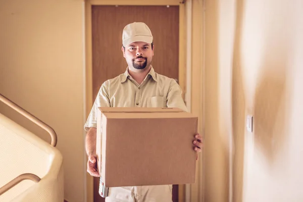 Mensajero entregando un paquete a su puerta —  Fotos de Stock