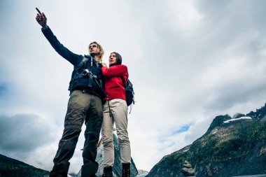 Dağ tepe üzerinde duran genç Çift