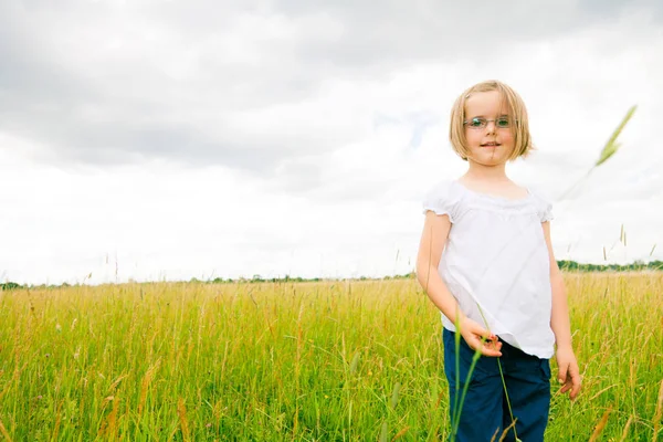 Yeşil çayır üzerinde küçük kız — Stok fotoğraf