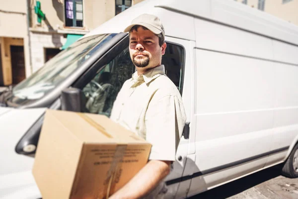 Mensajero entregando el paquete, de pie junto a su camioneta —  Fotos de Stock