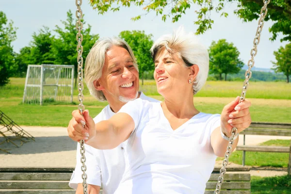 Casal sênior se divertindo no playground — Fotografia de Stock