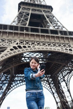 Eyfel Kulesi önünde genç Çinli kadın turist