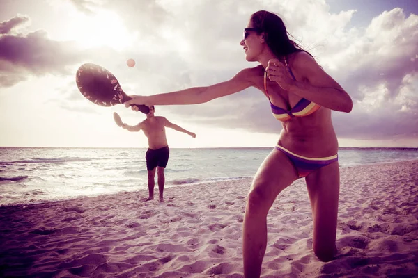 Pareja joven jugando tenis de playa —  Fotos de Stock