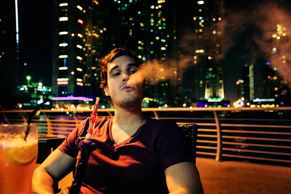 Jovem sentado no café, fumar Shisha — Fotografia de Stock