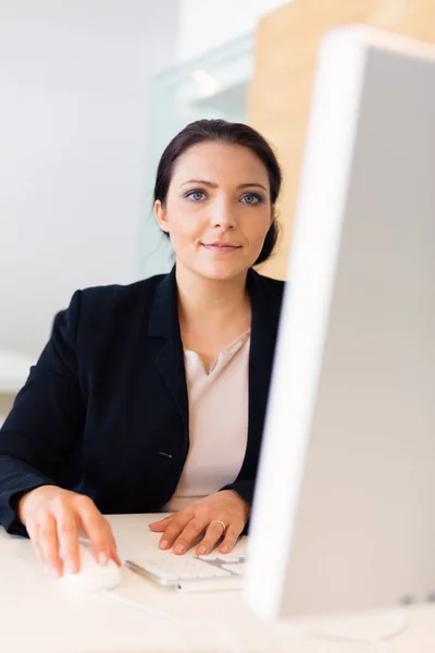 Mujer de negocios sentada en su escritorio — Foto de Stock