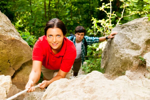 Jovem casal escalando uma montanha — Fotografia de Stock