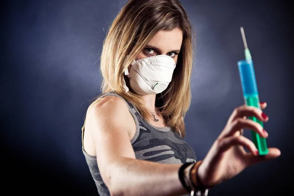 Mujer joven con una máscara de gripe, sosteniendo la cura — Foto de Stock