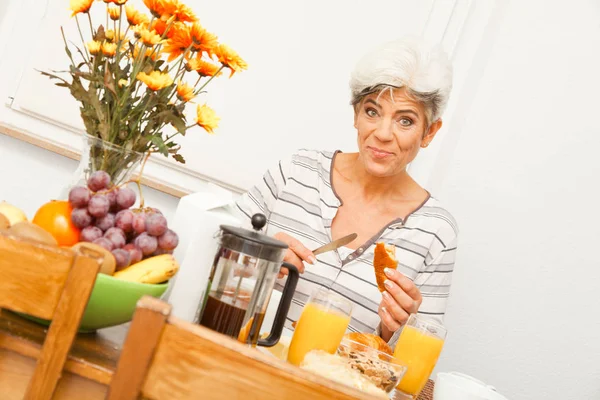 朝食を食べて幸せな成熟した女性 — ストック写真