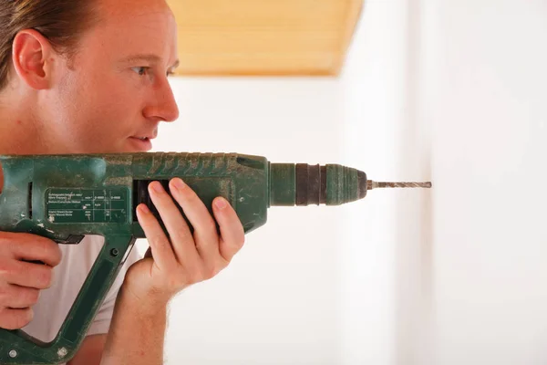 Young Man Drilling A Hole Into The Wall — Stock Photo, Image