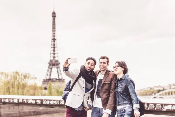 Grupo multiétnico de amigos divirtiéndose en París a lo largo del Sena —  Fotos de Stock