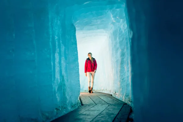 Mujer joven caminando a través de la cueva del glaciar — Foto de Stock