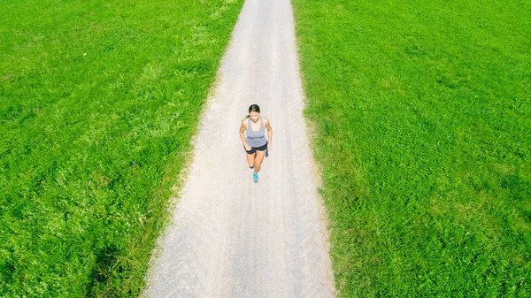 Mladá žena, běhání v polích — Stock fotografie
