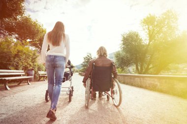 Tekerlekli sandalyede anne ile bebek arabası park