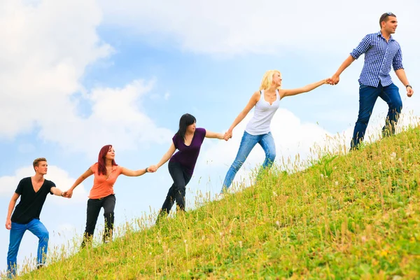 Young People Helping Each Other Climb A Hill — Stock Photo, Image