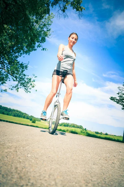 年轻女子骑她的独轮车 — 图库照片