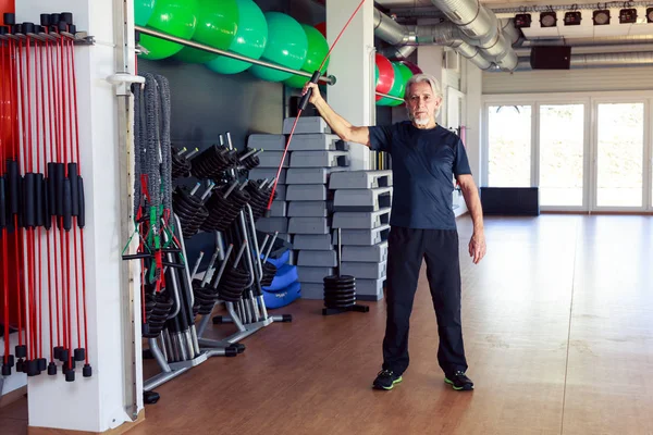 Hombre mayor caucásico haciendo ejercicio en el gimnasio — Foto de Stock