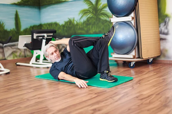 Hombre mayor caucásico haciendo ejercicio en el gimnasio — Foto de Stock