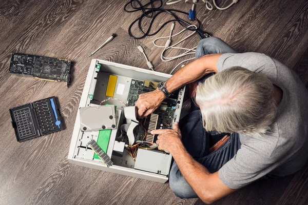 年配の男性がデスクトップ コンピューターの組み立て — ストック写真