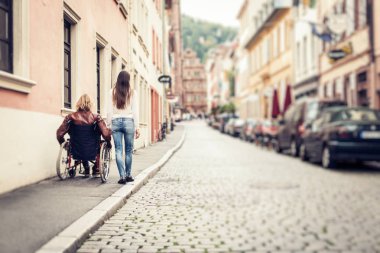 Şehirde geziniyor tekerlekli sandalyede genç Çift