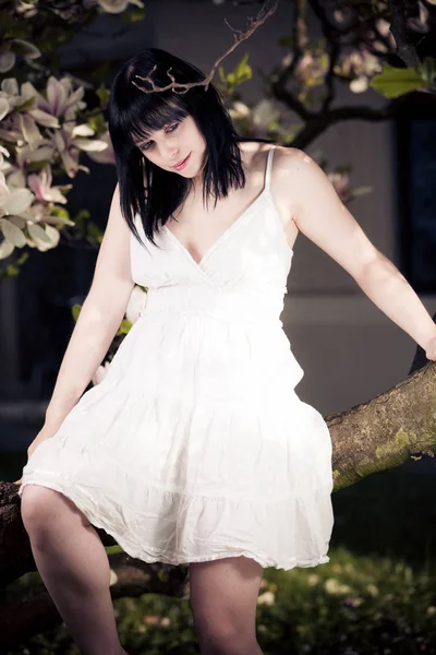 Jeune femme dans l'arbre Magnolia — Photo