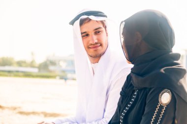 Arap çift sahilde oturmuş