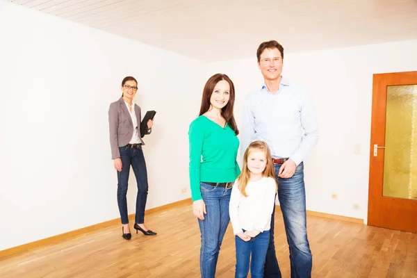 Família de três com seu agente imobiliário — Fotografia de Stock