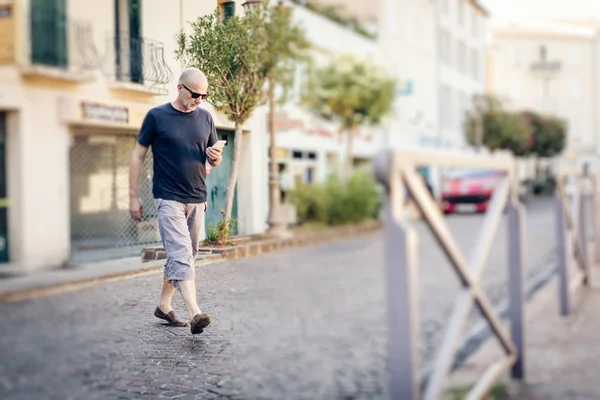 Homem atravessando a rua olhando para seu telefone — Fotografia de Stock