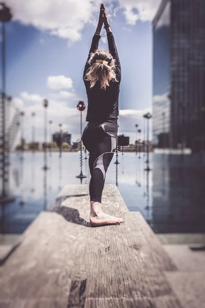 Mujer haciendo yoga cerca del lago en un entorno urbano, París —  Fotos de Stock
