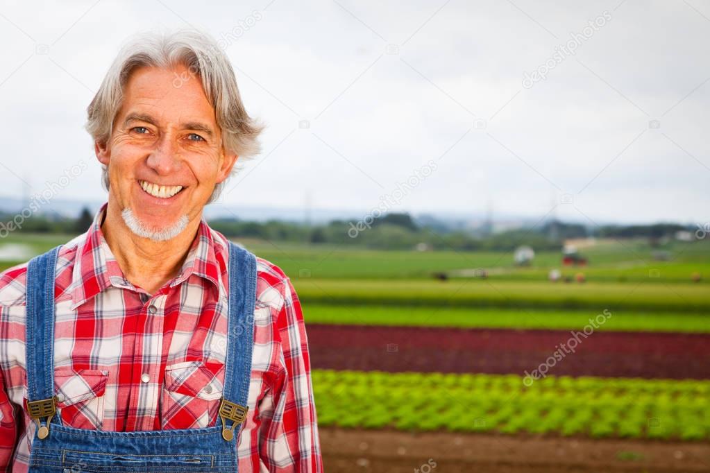 Farmer Standing In Front Of His Field