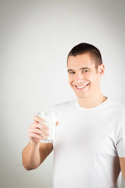 Mladý muž se sklenicí mléka — Stock fotografie