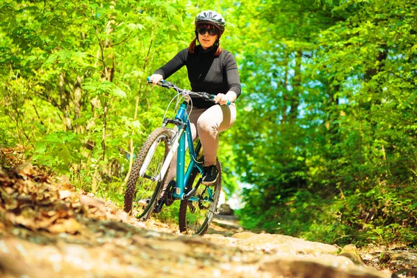 Mujer joven montando su bicicleta de montaña — Foto de Stock