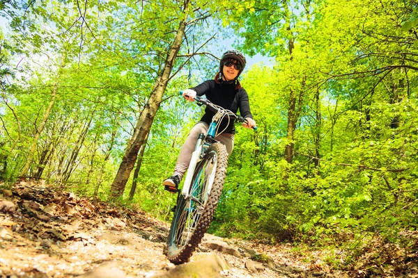 Mujer joven montando su bicicleta de montaña — Foto de Stock