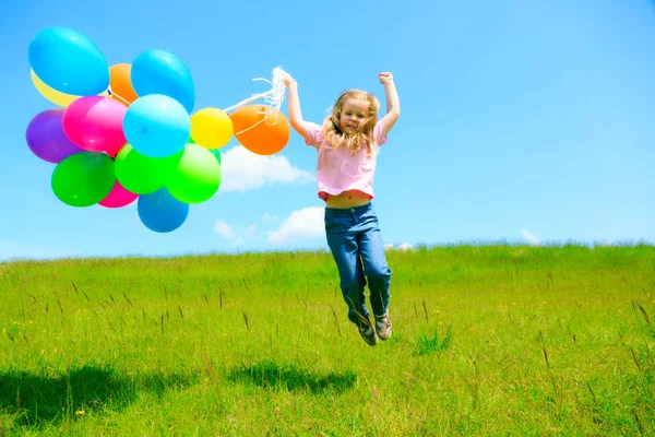 Liten flicka med färgglada ballonger — Stockfoto