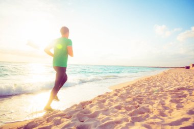 genç adam sahilde koşu