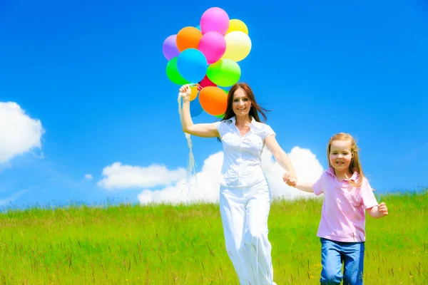 Mère et fille avec des ballons colorés — Photo