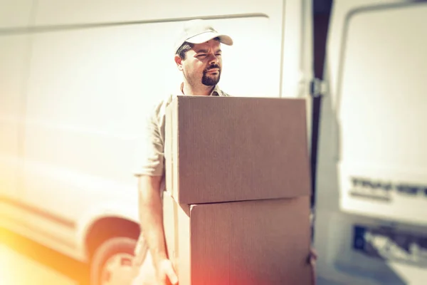 Mensageiro entregando parcela, de pé ao lado de sua van — Fotografia de Stock