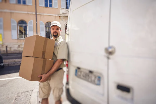 Mensajero entregando el paquete, de pie junto a su camioneta —  Fotos de Stock