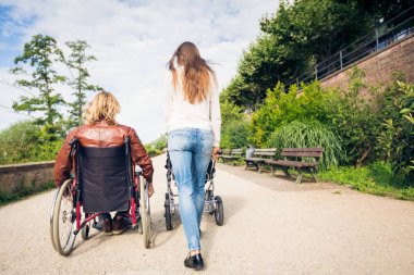 Tekerlekli sandalyede anne ile bebek arabası park