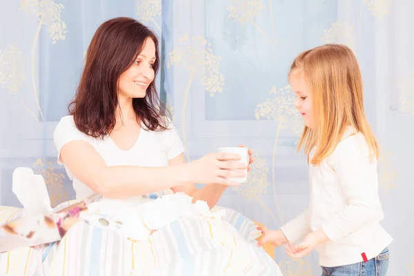 Menina trazendo sua mãe uma xícara de chá — Fotografia de Stock