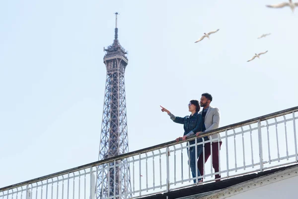 Multiethnisches Paar amüsiert sich in Paris in der Nähe des Eiffelturms — Stockfoto