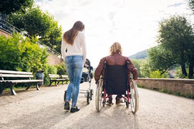 Tekerlekli sandalyede anne ile bebek arabası park