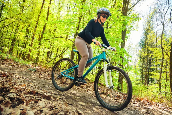 Mujer joven montando su bicicleta de montaña — Foto de Stock