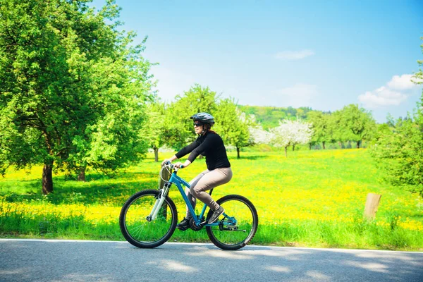 Mujer joven montando su bicicleta de montaña — Foto de Stock