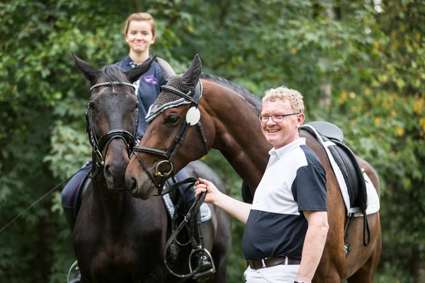 Homem e menina adultos com seus cavalos — Fotografia de Stock