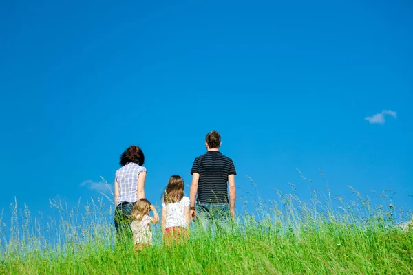 Familie steht auf einem Hügel — Stockfoto