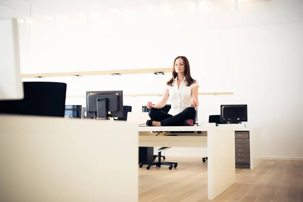 Kobieta robi joga w urzędzie — Zdjęcie stockowe