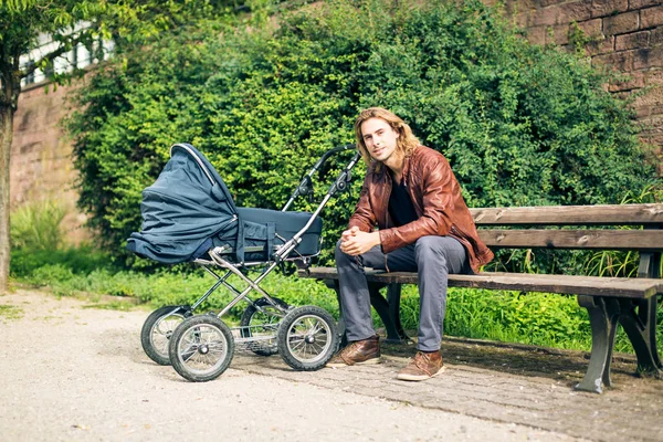 Giovane padre con passeggino nel parco — Foto Stock