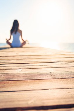 Genç kadın iskelede yoga yaparken